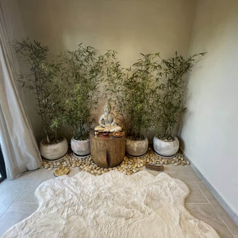 Indoor Zen corner with Buddha statue and bamboo plants for relaxation and tranquility.