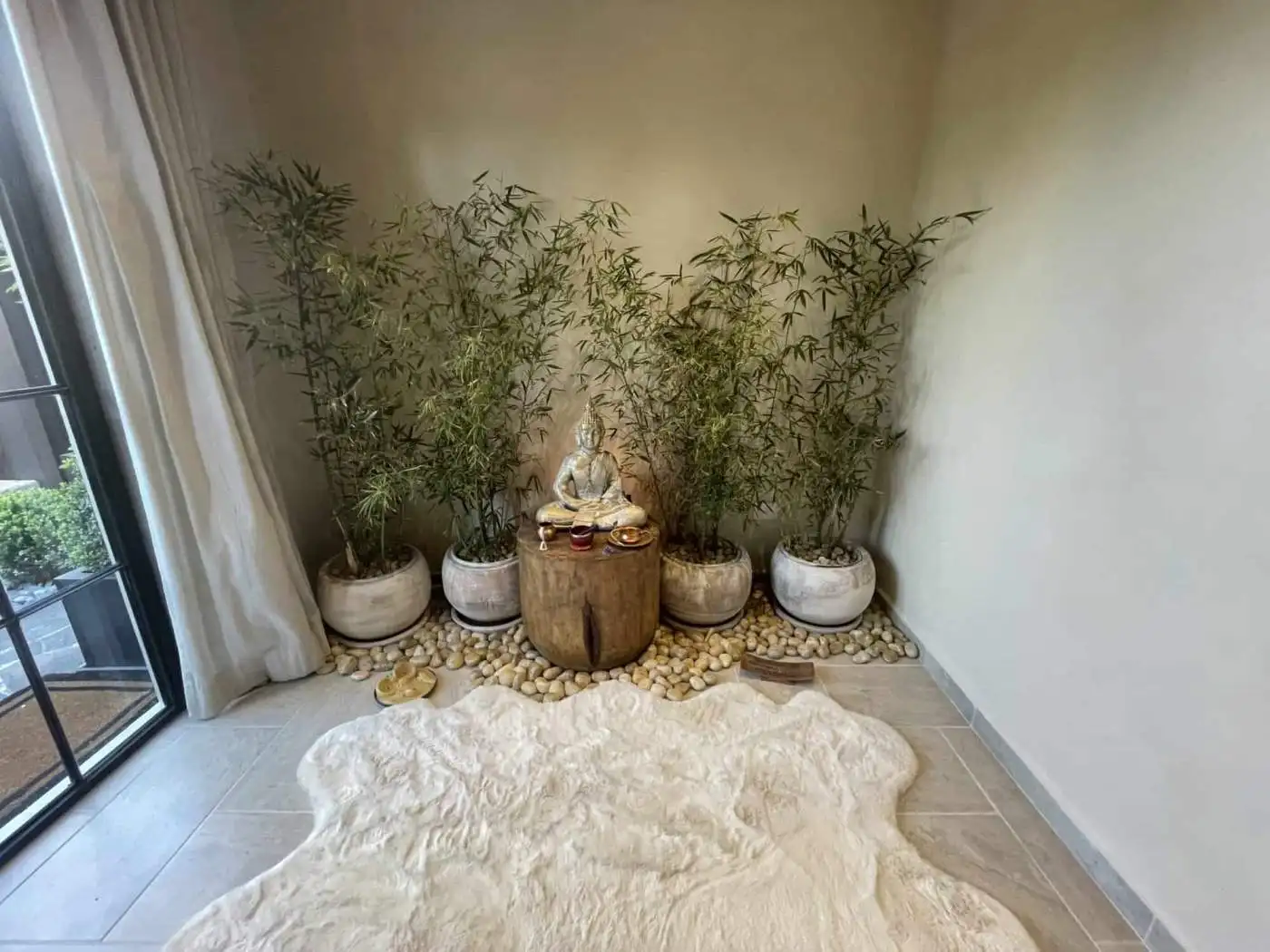Indoor Zen corner with Buddha statue and bamboo plants for relaxation and tranquility.