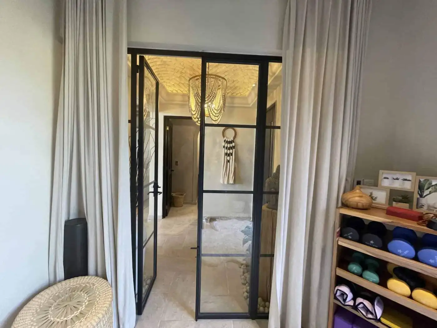 Modern glass door with black frame separating indoor and outdoor spaces.