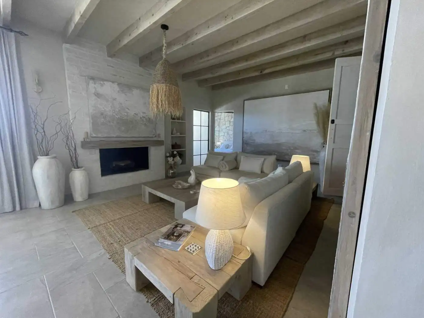 Cozy living room with beige sofas, wooden accents, and natural light in a stylish home.