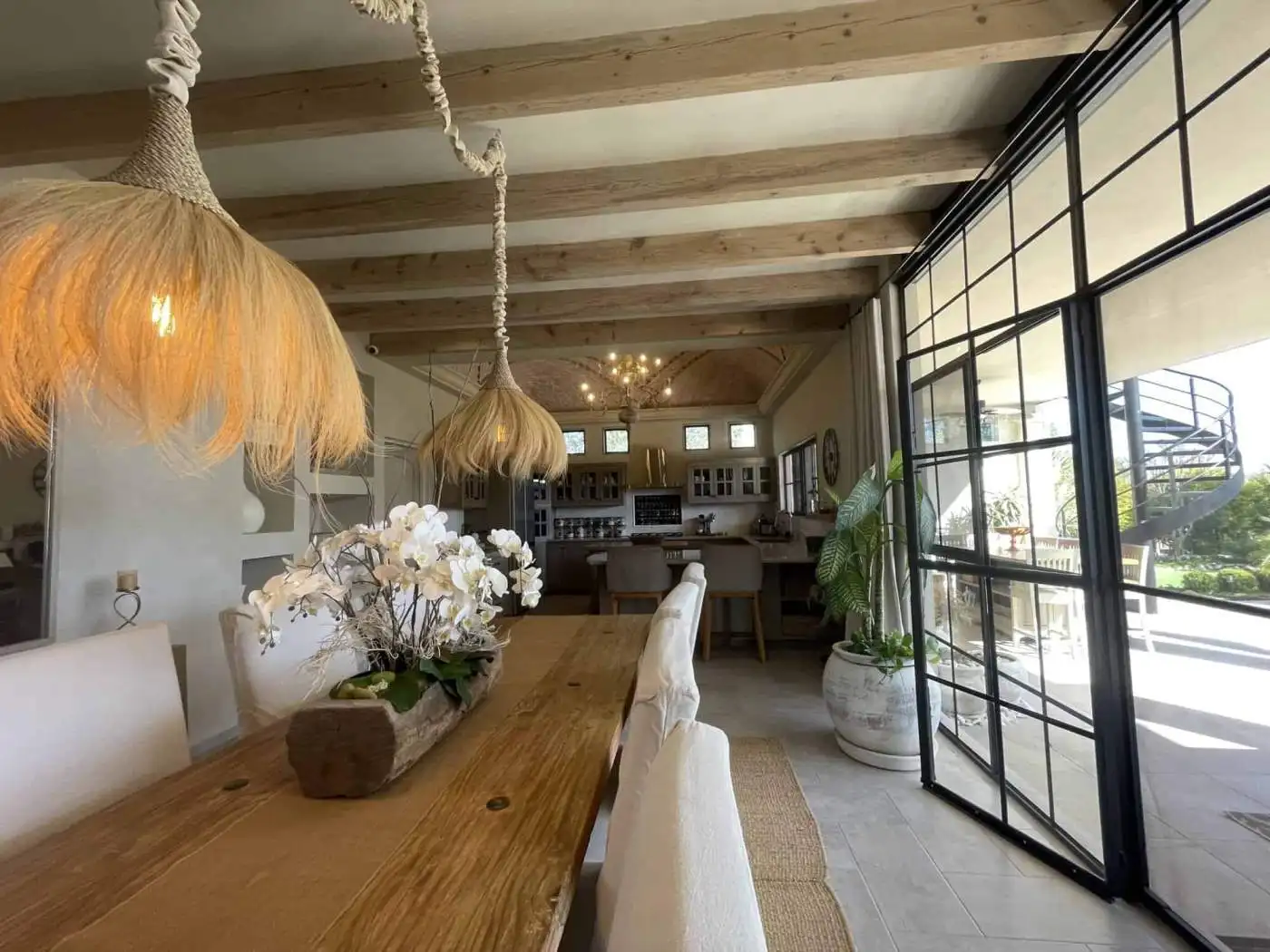 Bright and airy living space with wooden accents and large glass doors.
