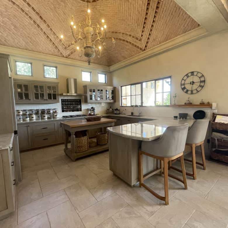 Modern kitchen with stylish cabinetry, large windows, and a central island for cooking and dining.