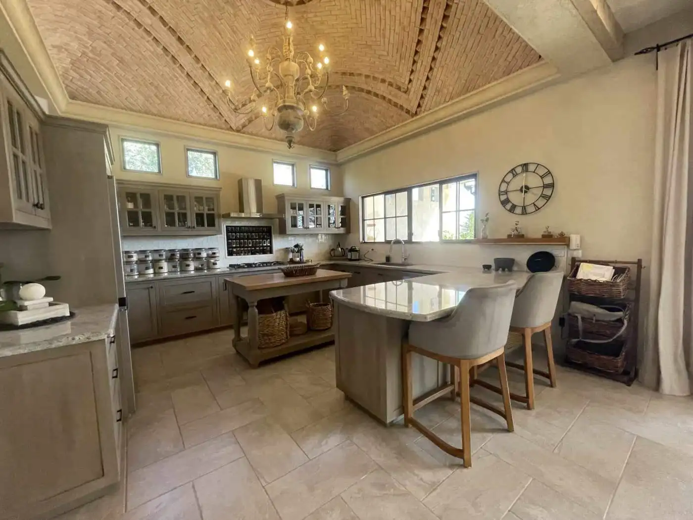 Modern kitchen with stylish cabinetry, large windows, and a central island for cooking and dining.