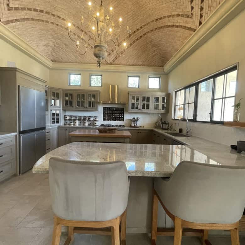 Modern kitchen with vaulted brick ceiling, stylish lighting, and spacious layout.
