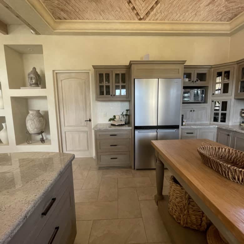 Modern kitchen with stainless steel refrigerator and wooden cabinetry for a stylish look.
