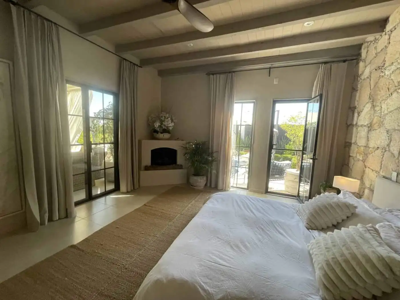 Spacious living room with large windows, neutral decor, and outdoor access.