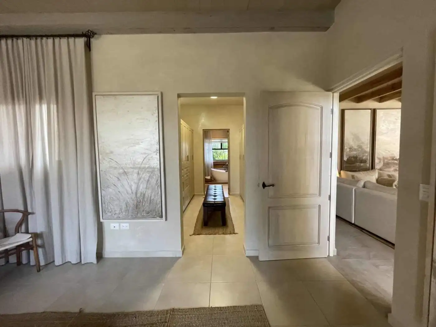 Spacious living room with large windows, neutral tones, and comfortable seating.