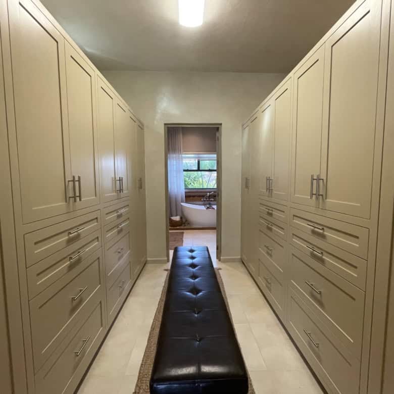 Luxury walk-in closet with custom built-in wardrobes and ample storage space.