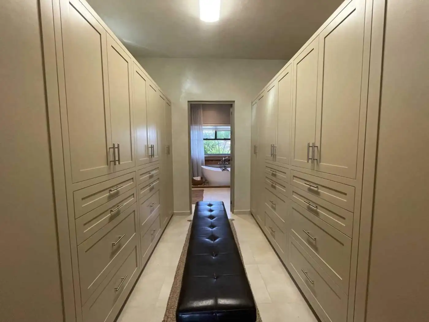 Luxury walk-in closet with custom built-in wardrobes and ample storage space.