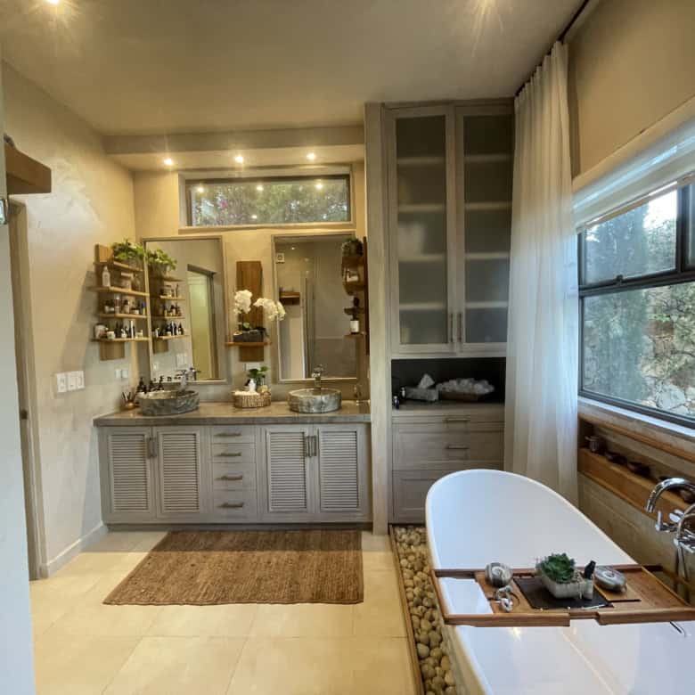 Home spa bathroom with large window and modern decor.
