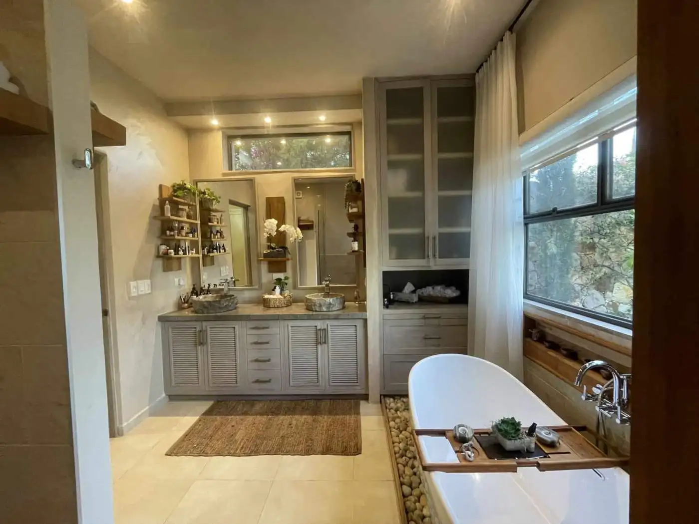 Home spa bathroom with large window and modern decor.