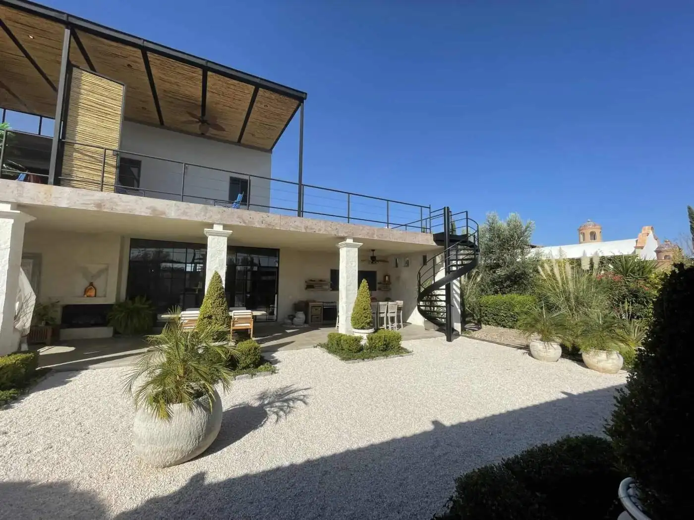 Luxury villa with spacious outdoor terrace and lush garden surroundings.