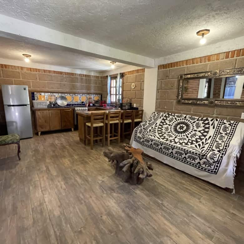 Spacious living area with open kitchen, rustic brick walls, and stylish decor, perfect for comfortab.