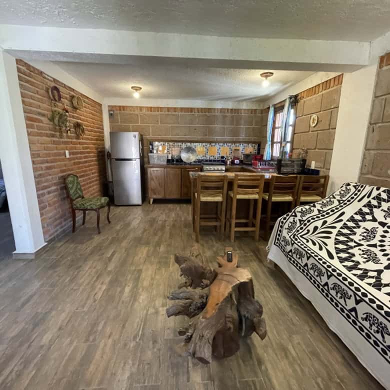 Spacious living and kitchen area with rustic decor and wooden furniture.