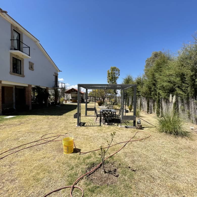 Spacious backyard featuring a garden, outdoor seating, and a pergola for relaxing outdoor activities.