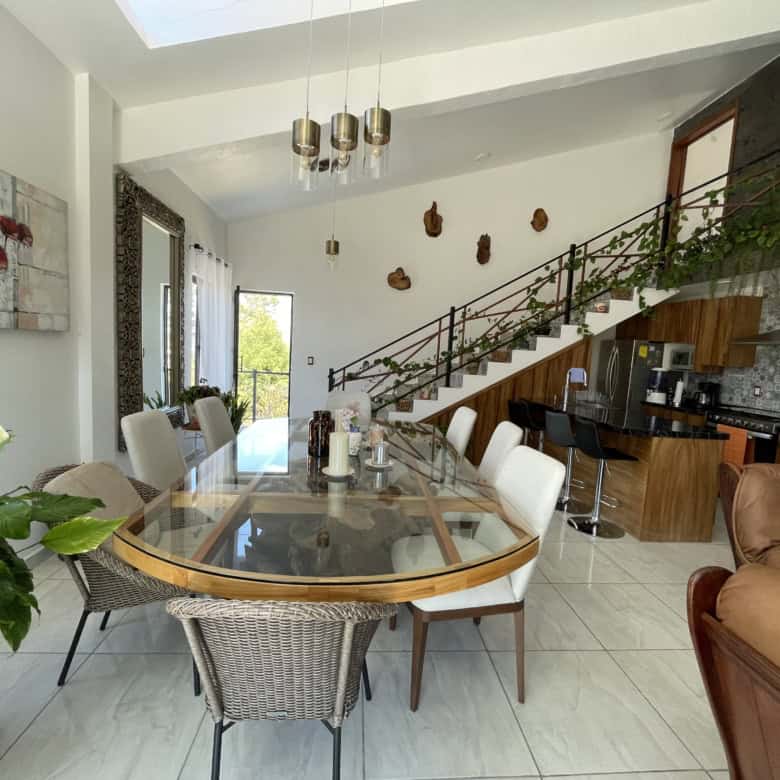 Contemporary interior with dining table, staircase, and cozy seating.