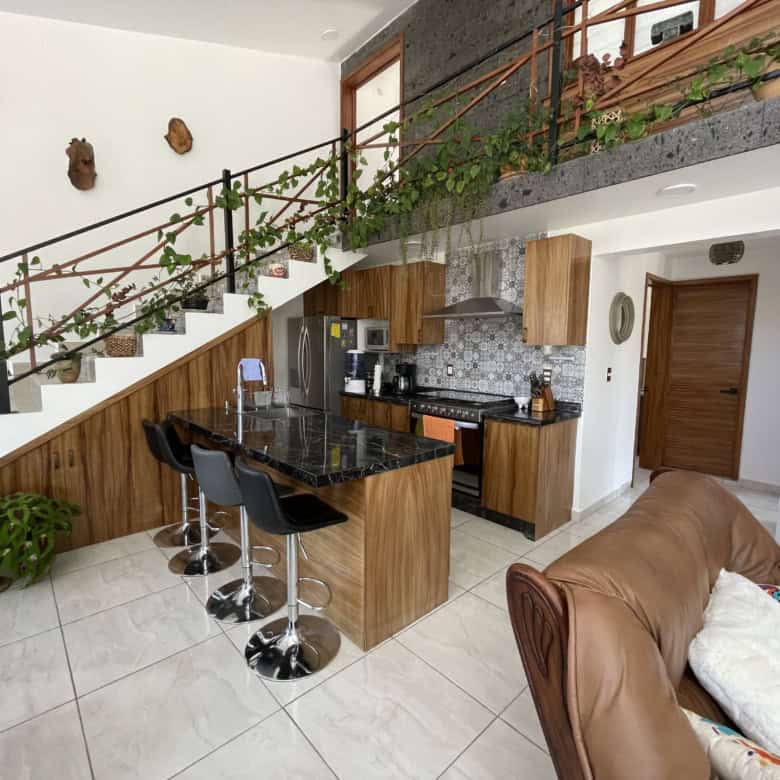 Spacious kitchen and living area featuring contemporary design, wooden accents, and a cozy seating a.