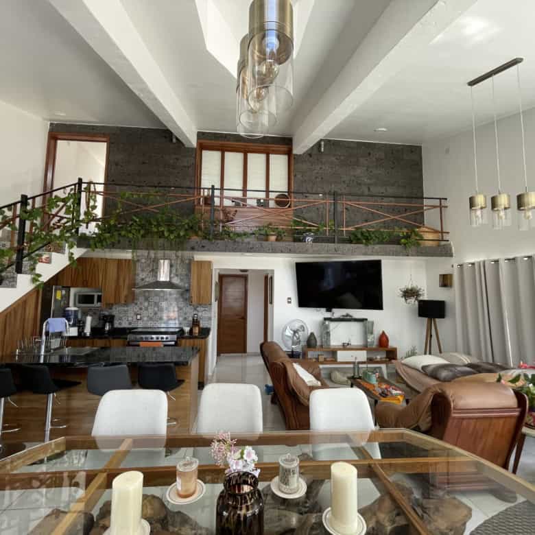Spacious open-plan living room featuring a loft, modern kitchen, and stylish furniture for comfortab.