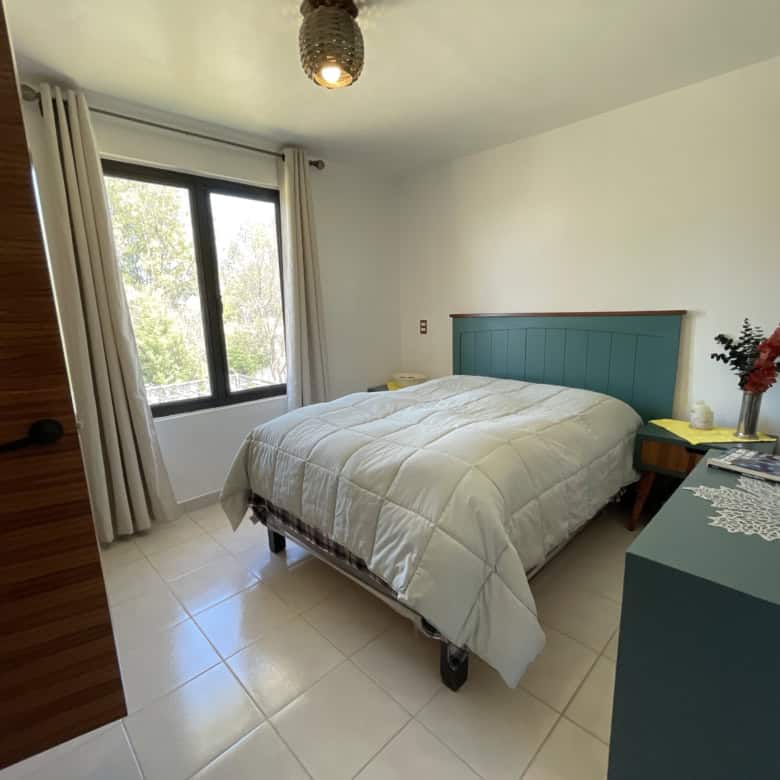 Bright bedroom with large window and modern decor.