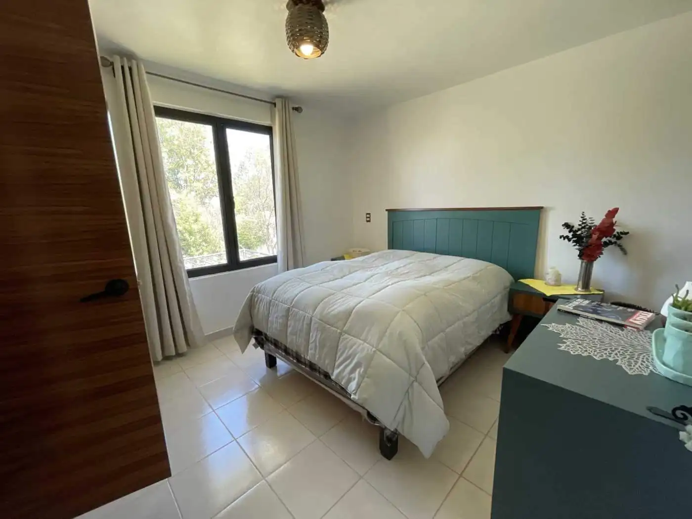Bright bedroom with large window and modern decor.