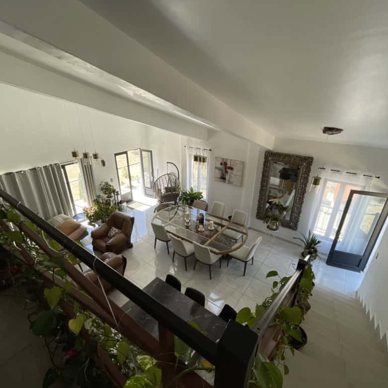 Spacious living room with large windows, modern furniture, and elegant decor for comfortable living.