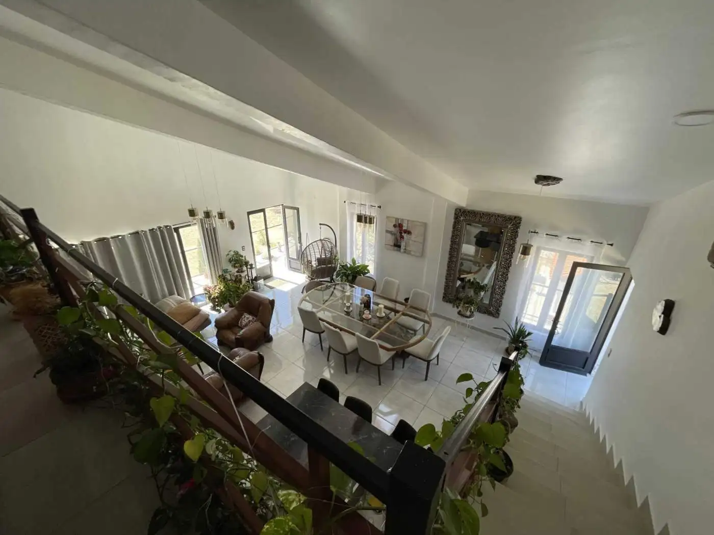 Spacious living room with large windows, modern furniture, and elegant decor for comfortable living.