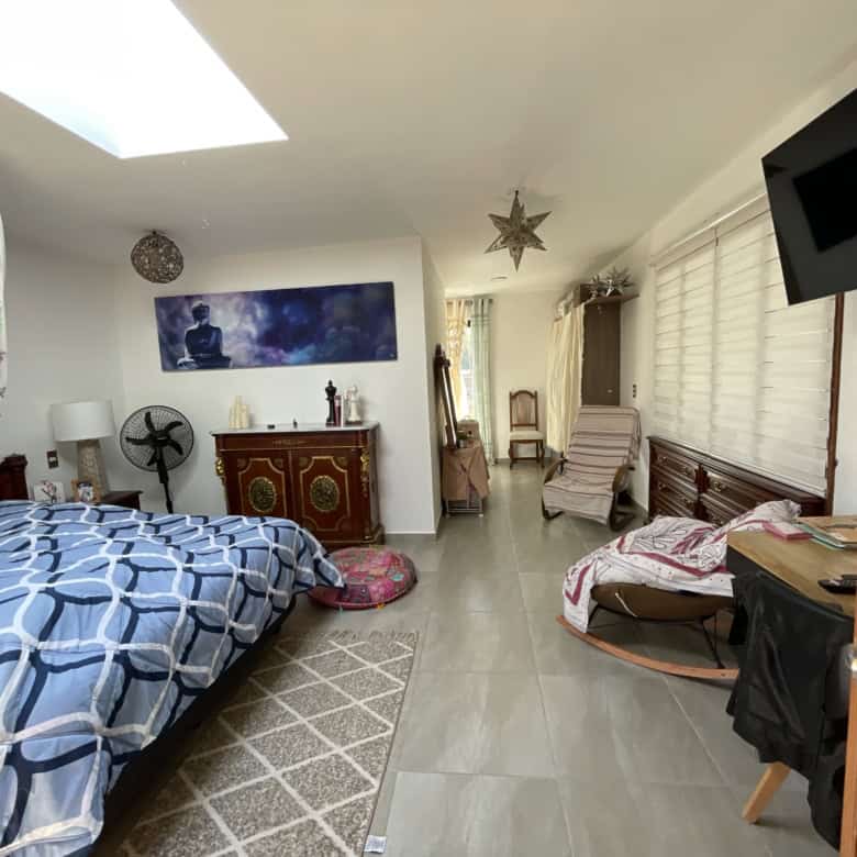 Bright bedroom featuring a large skylight and modern decor.