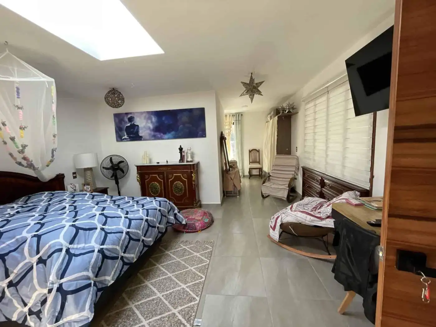 Bright bedroom featuring a large skylight and modern decor.