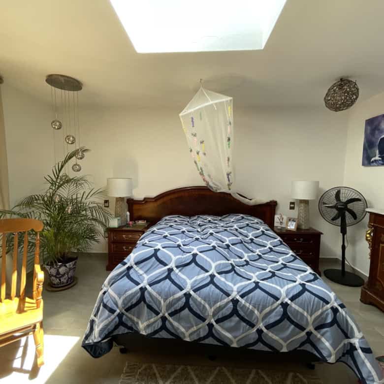 Bright bedroom with a skylight, wooden furniture, and decorative elements creating a relaxing atmosp.