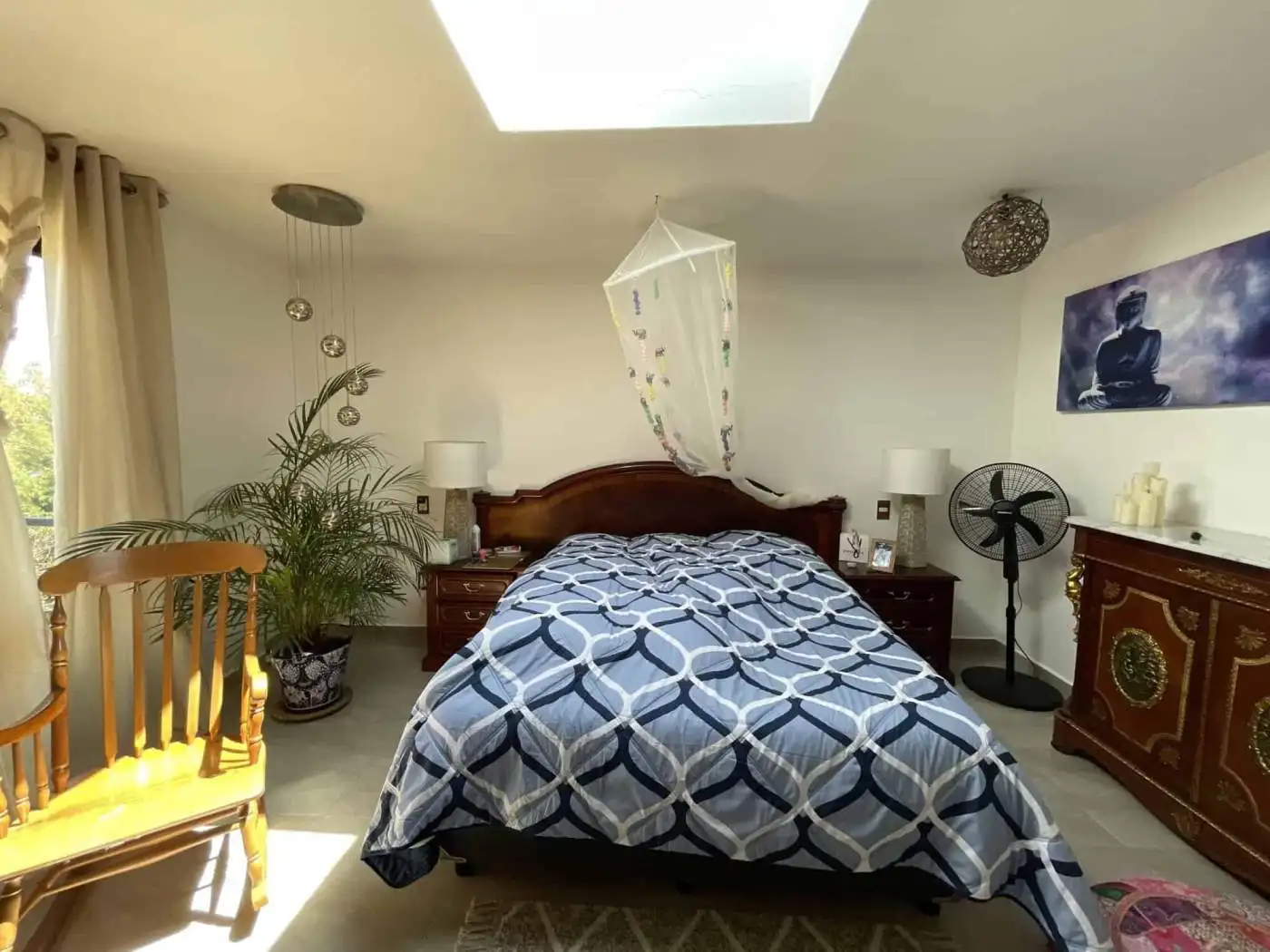 Bright bedroom with a skylight, wooden furniture, and decorative elements creating a relaxing atmosp.