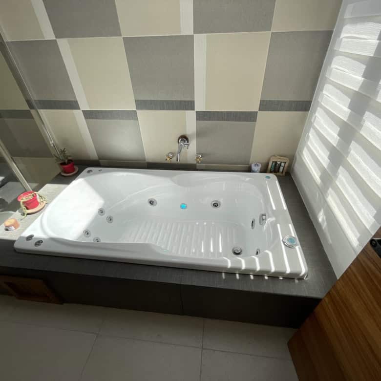 Luxurious white jacuzzi bathtub in a contemporary bathroom setting.