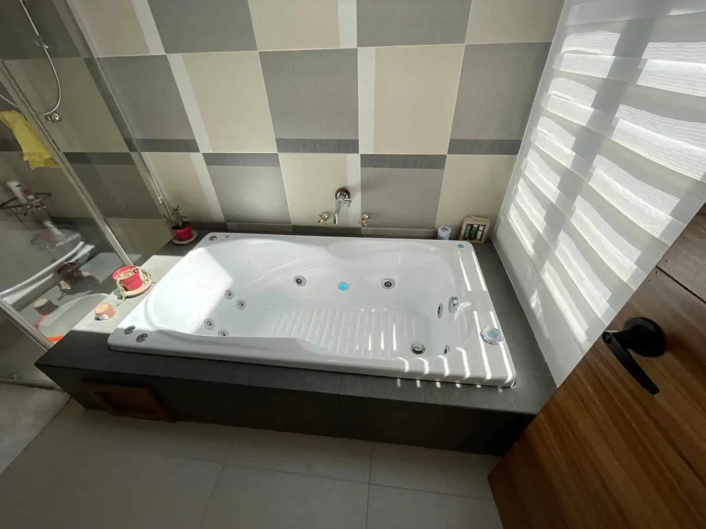 Luxurious white jacuzzi bathtub in a contemporary bathroom setting.