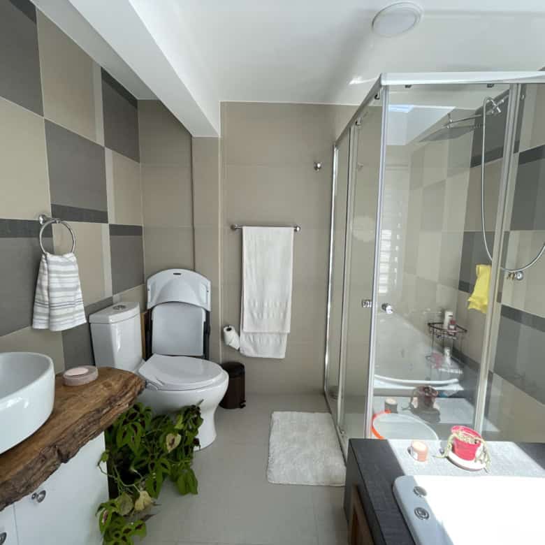 Modern bathroom with glass shower enclosure and wooden vanity for a stylish look.