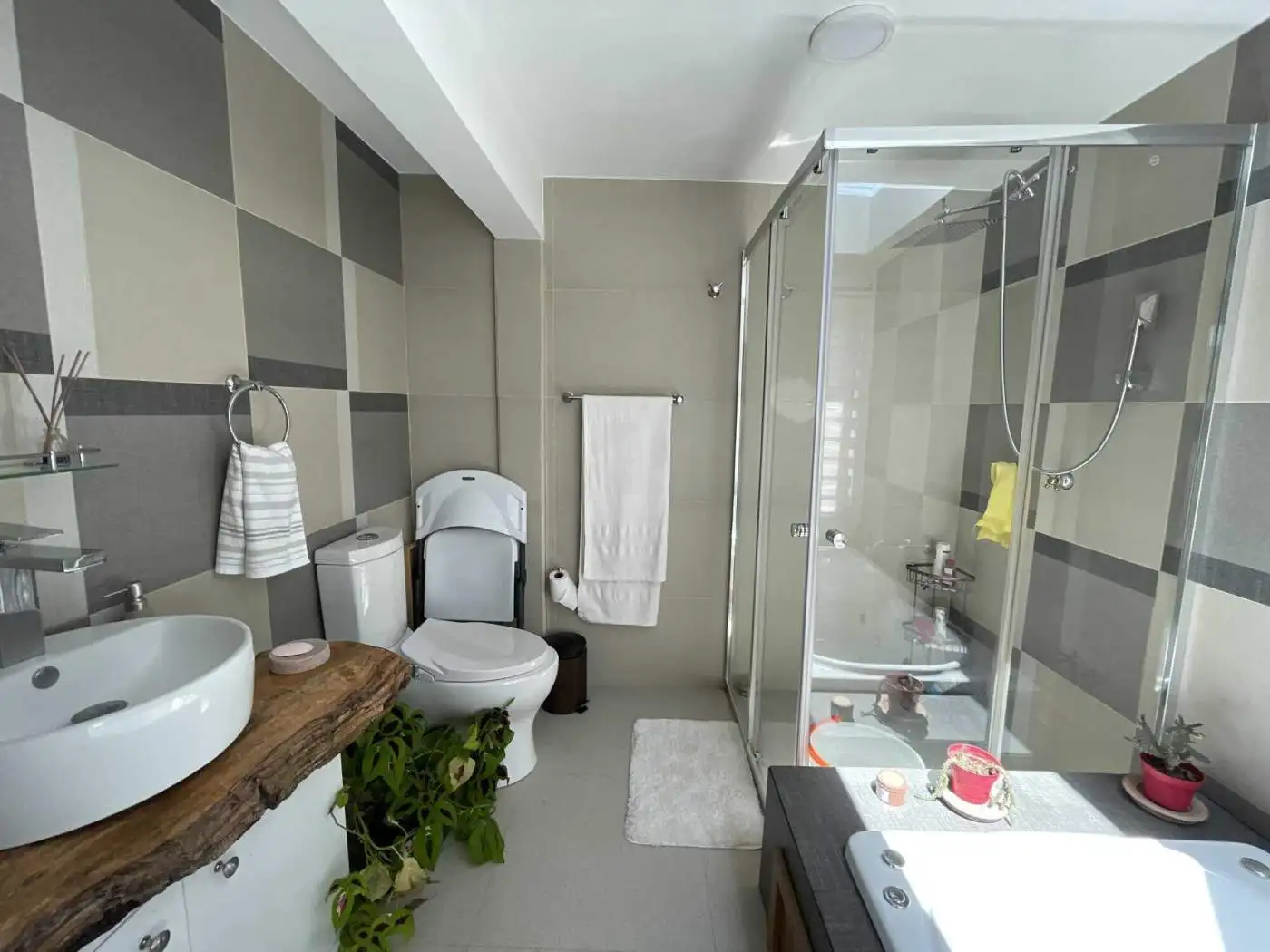 Modern bathroom with glass shower enclosure and wooden vanity for a stylish look.