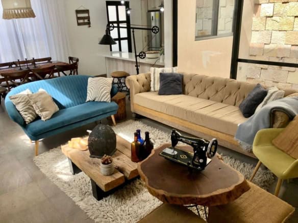 Cozy modern living room featuring vintage-style sofas, a rustic coffee table, and decorative accesso.