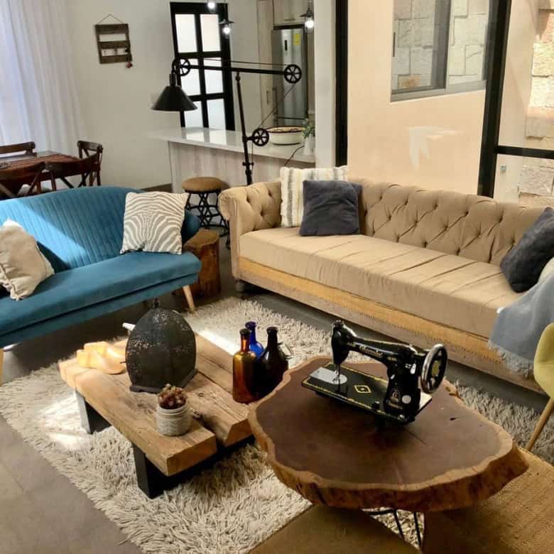 Cozy modern living room featuring vintage-style sofas, a rustic coffee table, and decorative accesso.