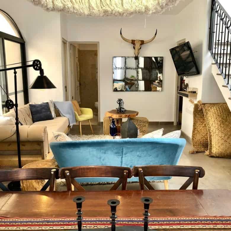 Cozy living room featuring rustic decor, a mix of modern furniture, and unique decorative elements l.