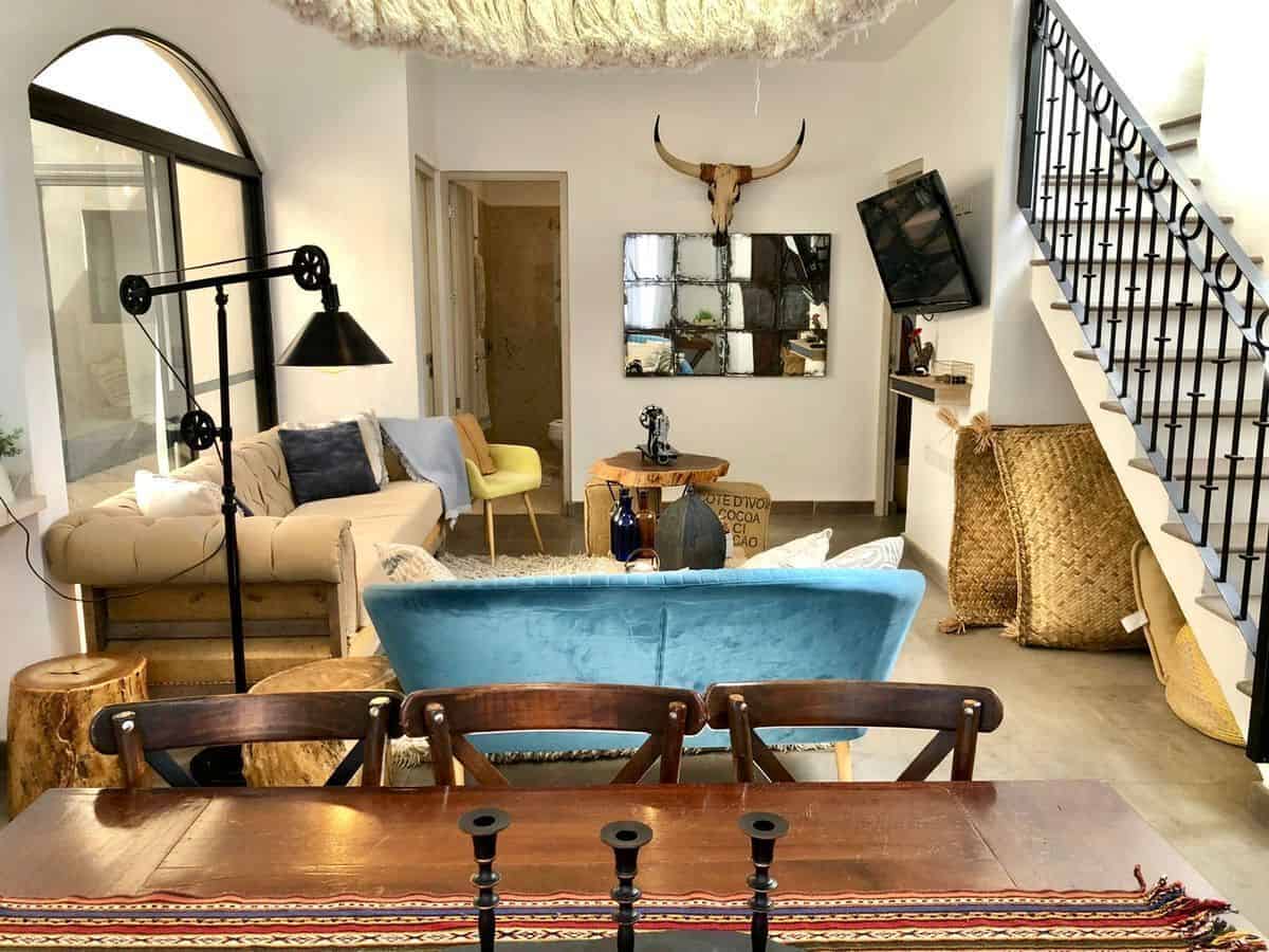 Cozy living room featuring rustic decor, a mix of modern furniture, and unique decorative elements l.