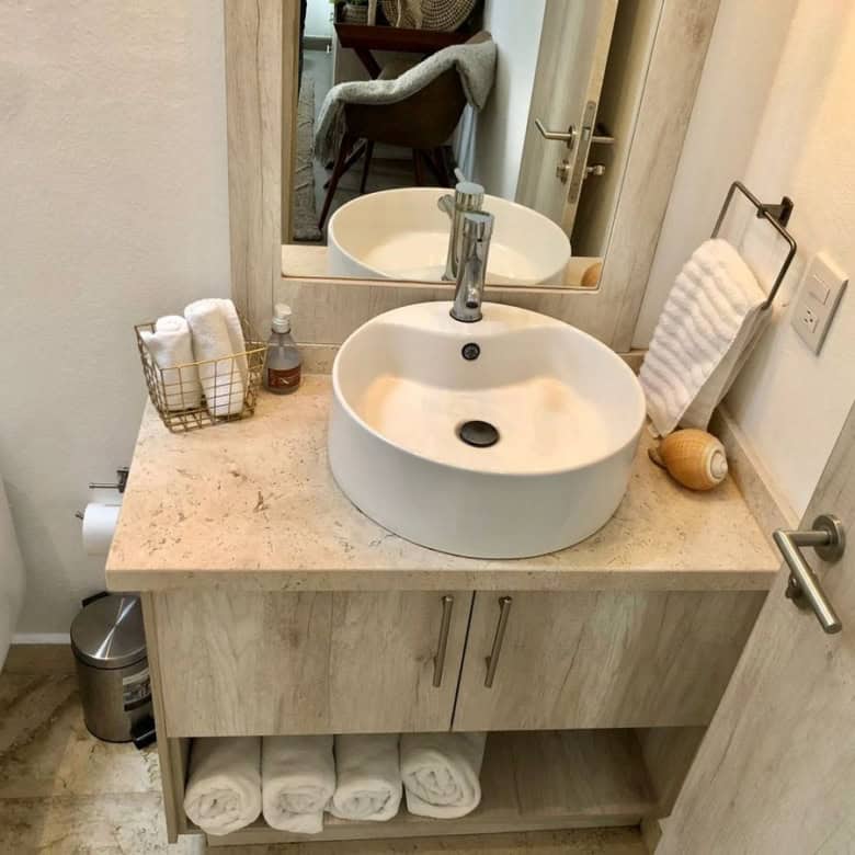 Modern bathroom with round vessel sink and wooden vanity for stylish home decor.