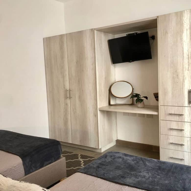 Modern bedroom with built-in wardrobe and wall-mounted TV for comfort and convenience.