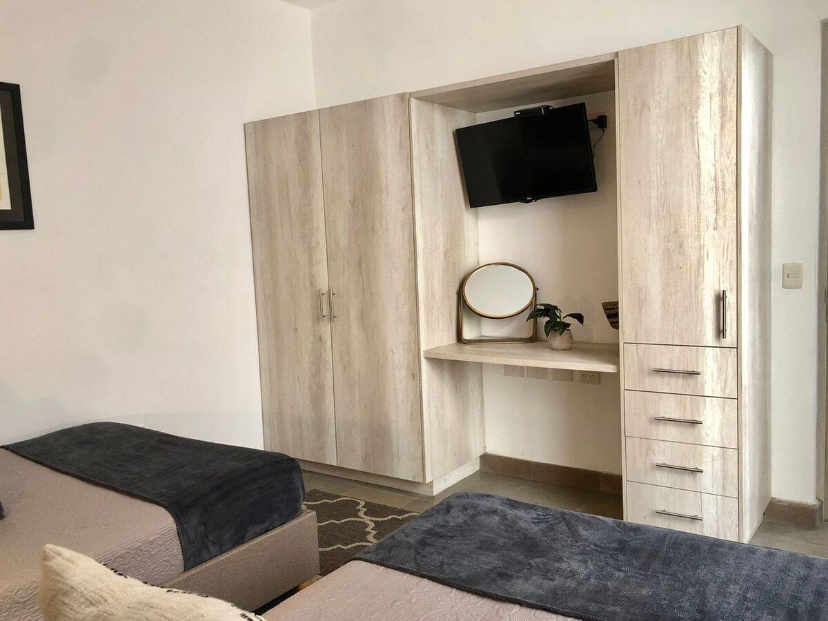 Modern bedroom with built-in wardrobe and wall-mounted TV for comfort and convenience.