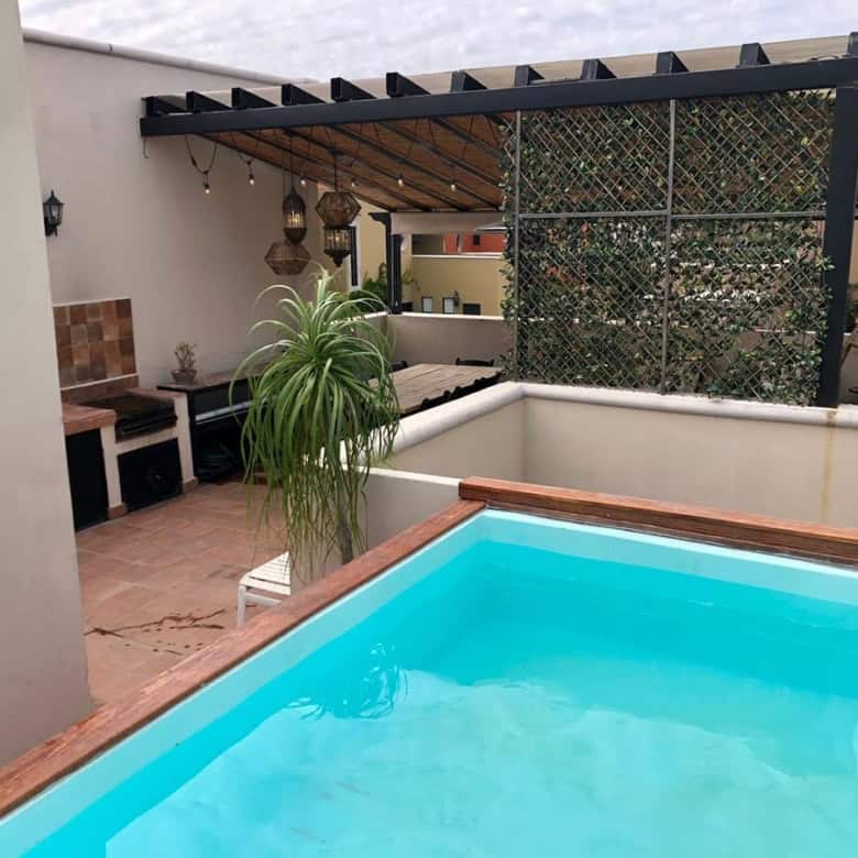 Rooftop pool with outdoor lounge and pergola, perfect for relaxing and entertaining in a stylish set.