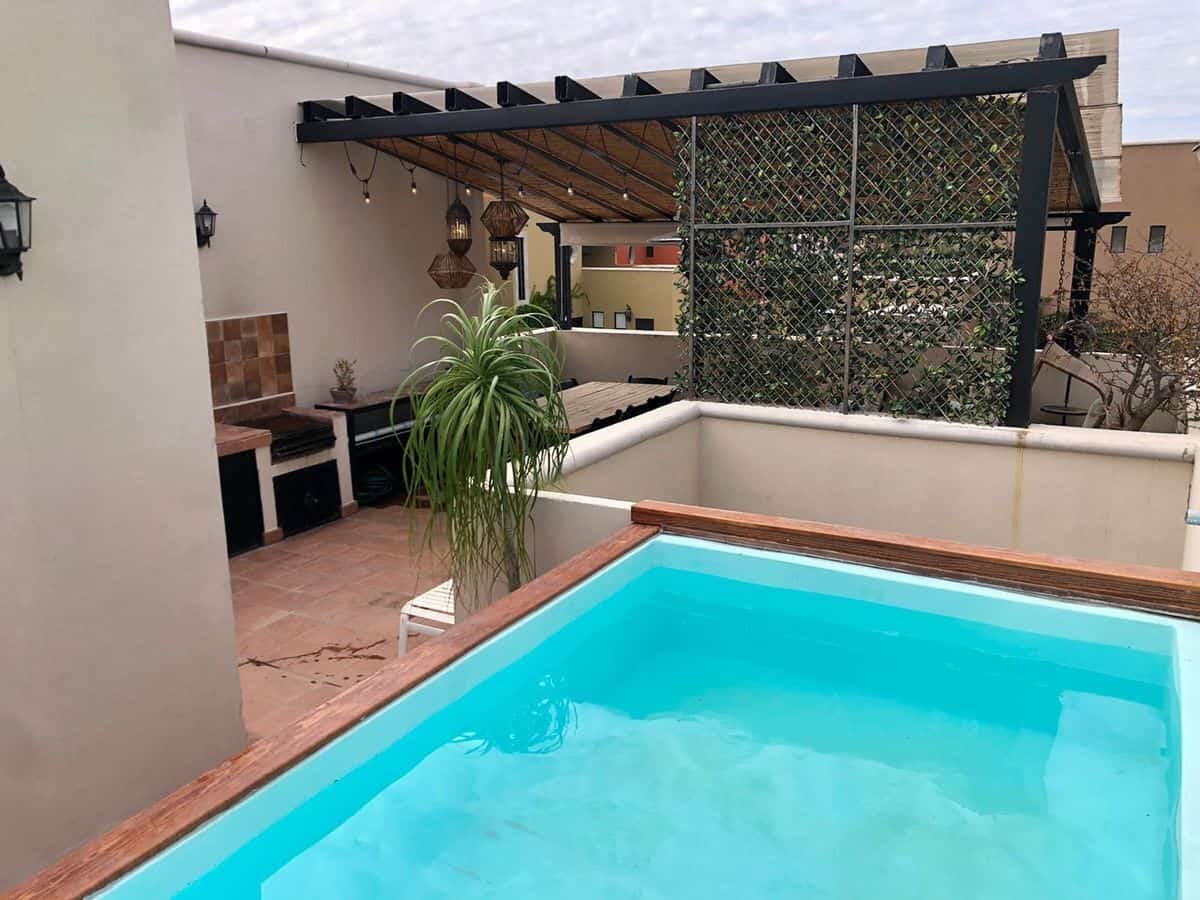 Rooftop pool with outdoor lounge and pergola, perfect for relaxing and entertaining in a stylish set.