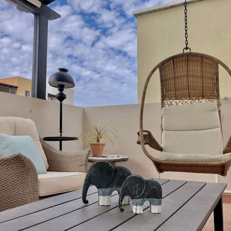 Outdoor terrace with swing and comfortable seating area.