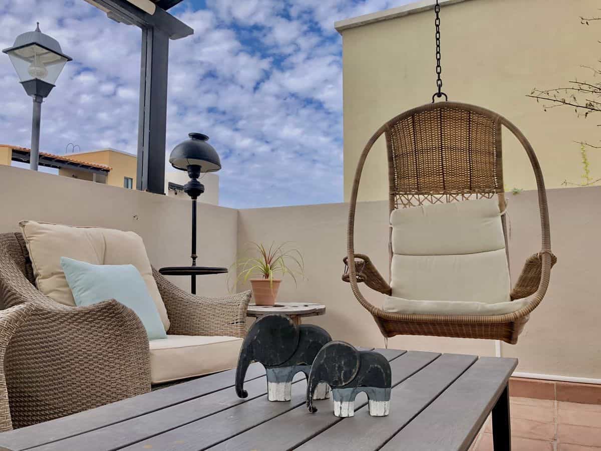 Outdoor terrace with swing and comfortable seating area.