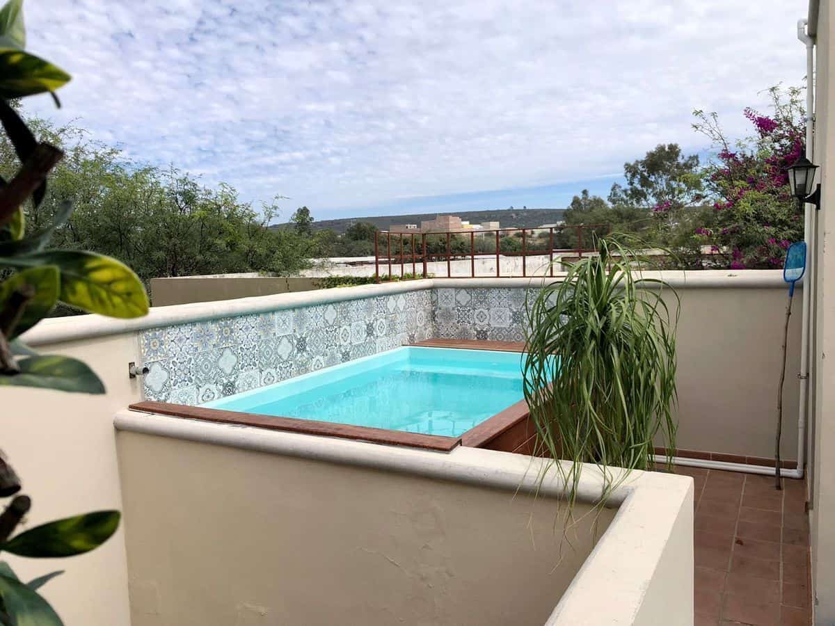 Rooftop pool overlooking lush landscape and sky, perfect for relaxation and leisure.