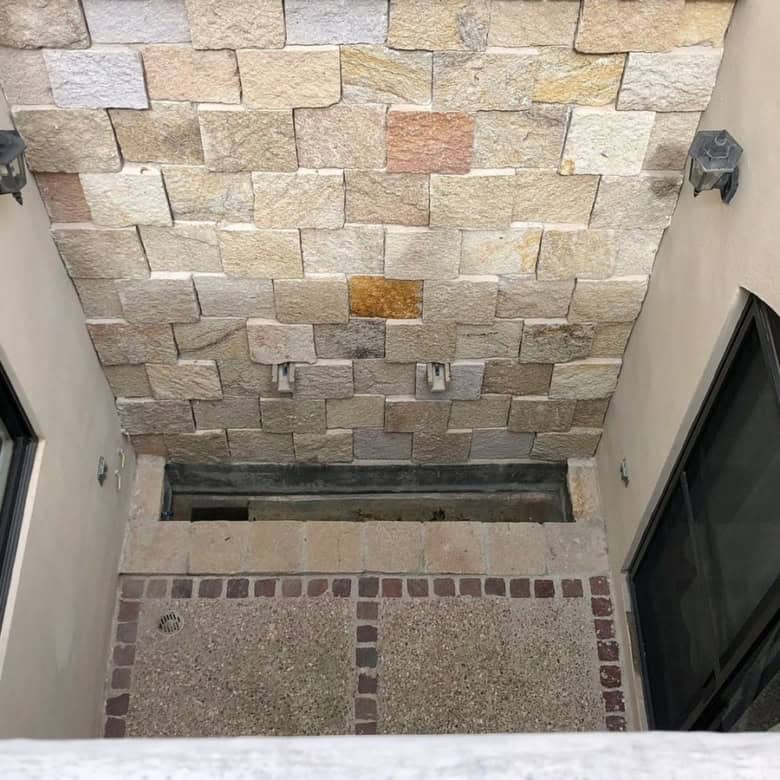 Modern courtyard with stone wall and glass doors for outdoor living.