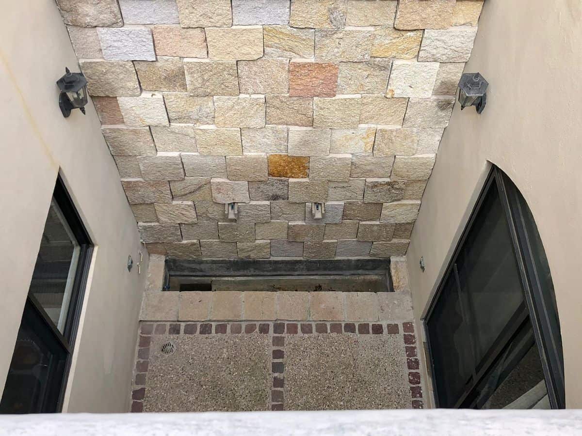Modern courtyard with stone wall and glass doors for outdoor living.