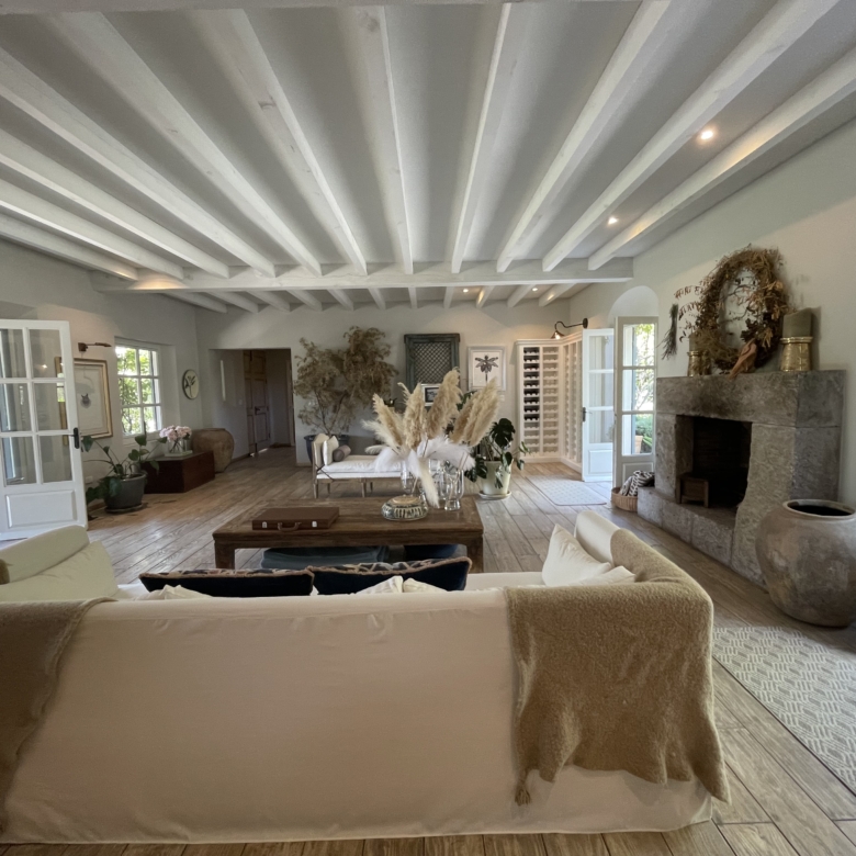 Modern living room with white sofas, fireplace, and large windows for natural light.