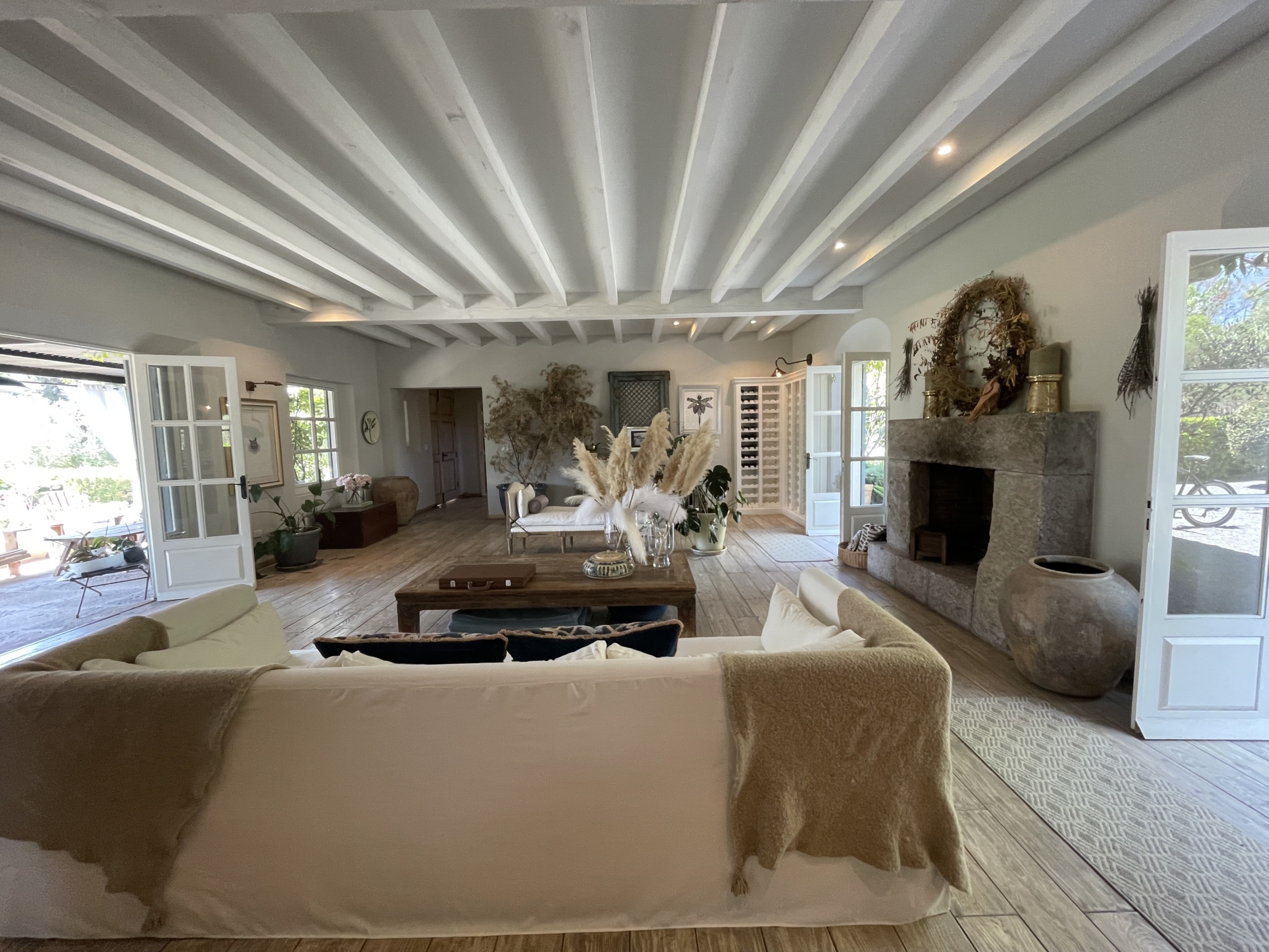 Modern living room with white sofas, fireplace, and large windows for natural light.